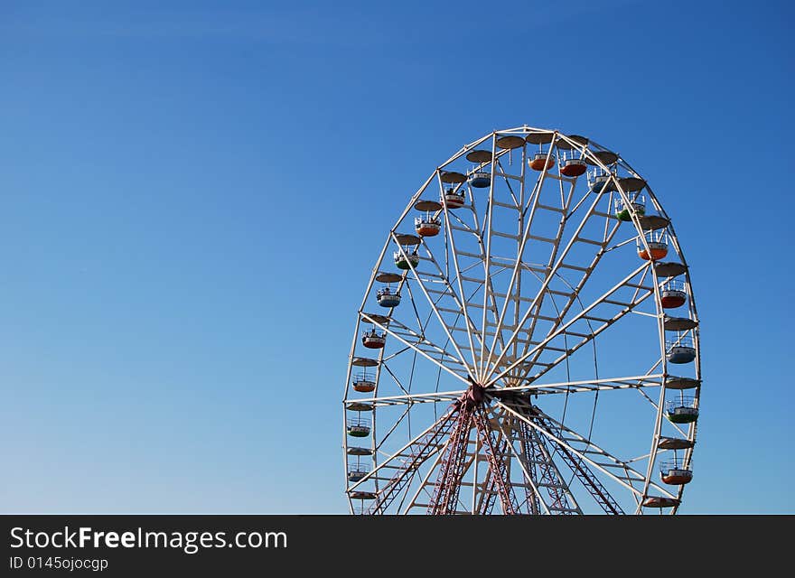 Ferris wheel on background blue sky