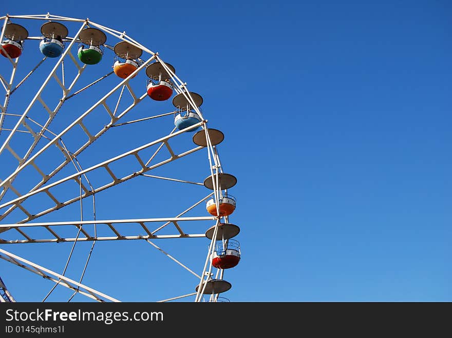 Ferris wheel on background blue sky