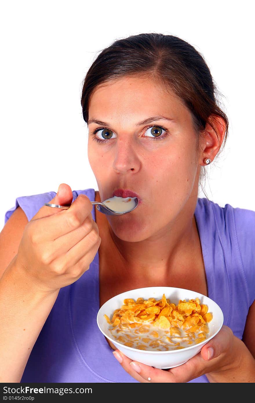 A young woman enjoys her crunchy cornflakes. Isolated over white. A young woman enjoys her crunchy cornflakes. Isolated over white.