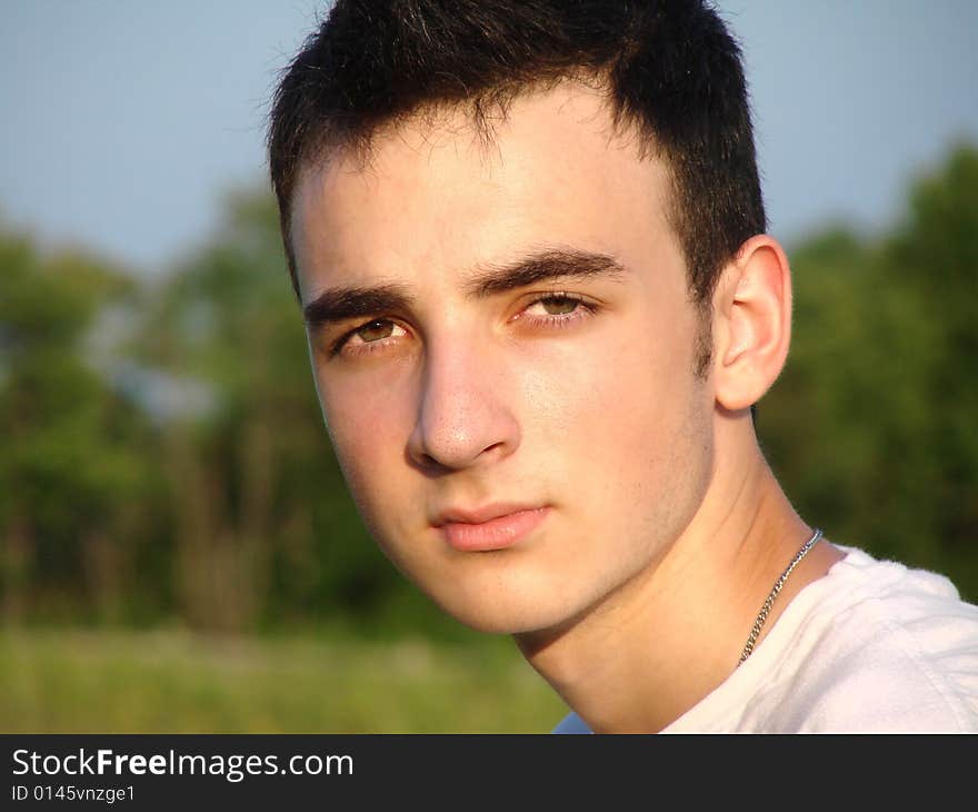 Cose-up of a young man in a field.