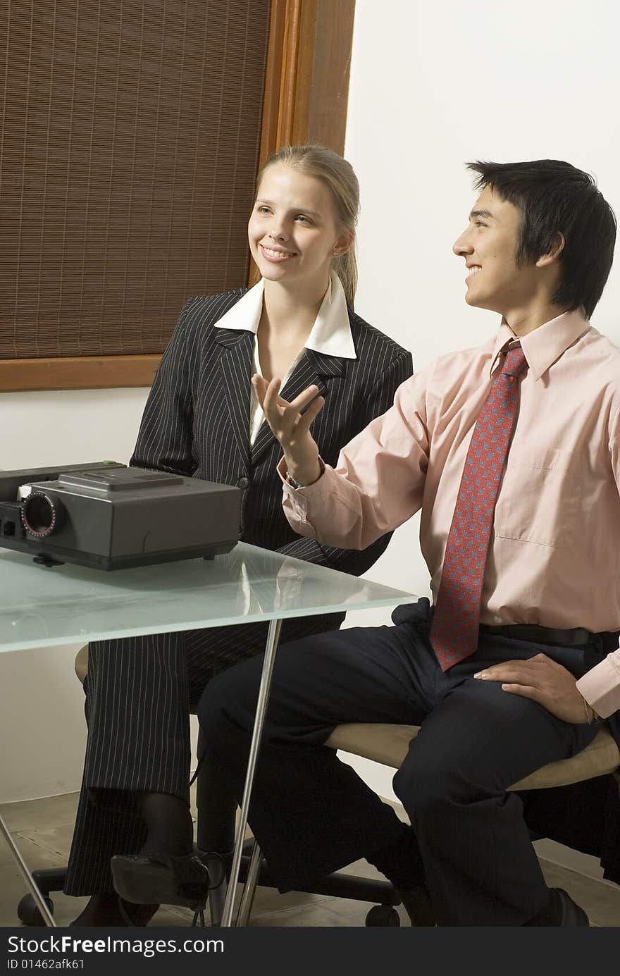 Business woman and man talking in a meeting in an office. Vertically framed photo.