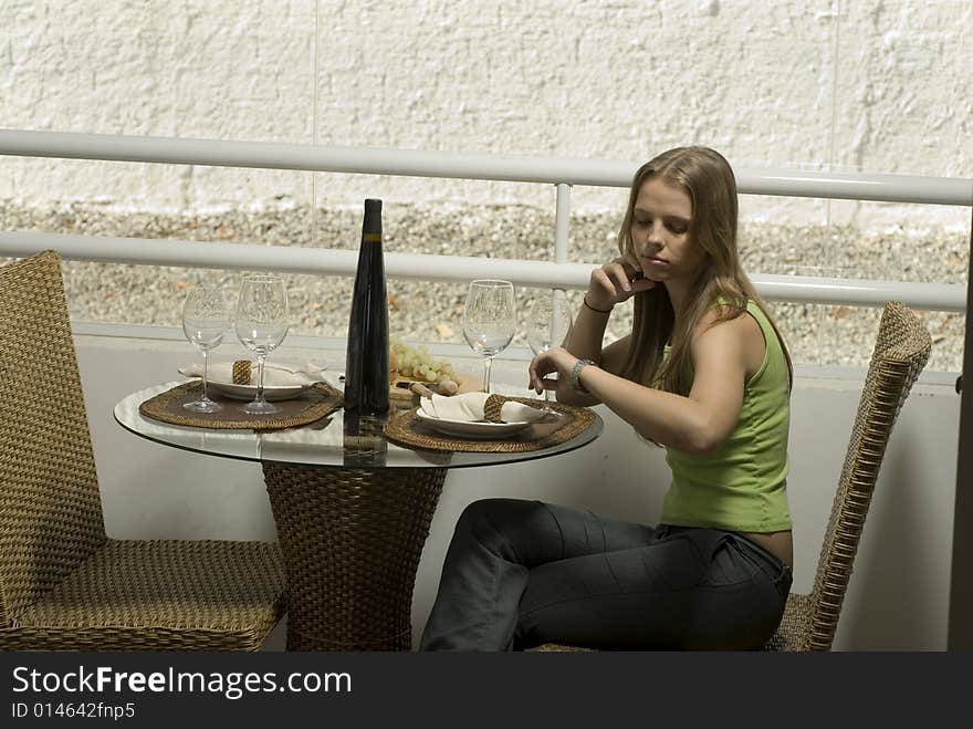 Young woman waiting for her date at a table for two. Horizontally framed shot. Young woman waiting for her date at a table for two. Horizontally framed shot.