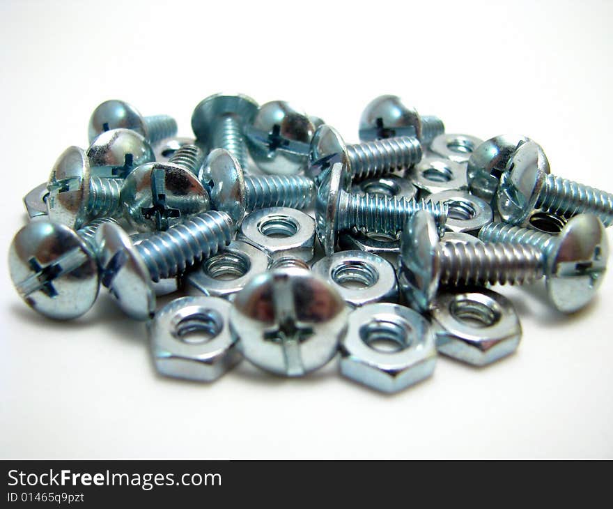 An arrangement of nuts and bolts on a white background