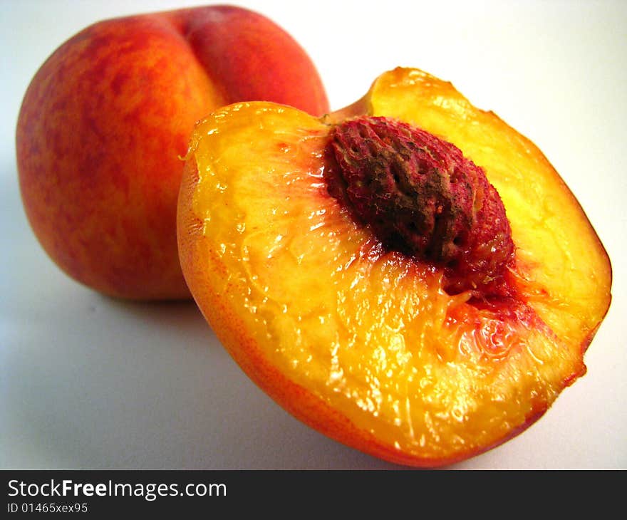 Two ripe peaches on a white background