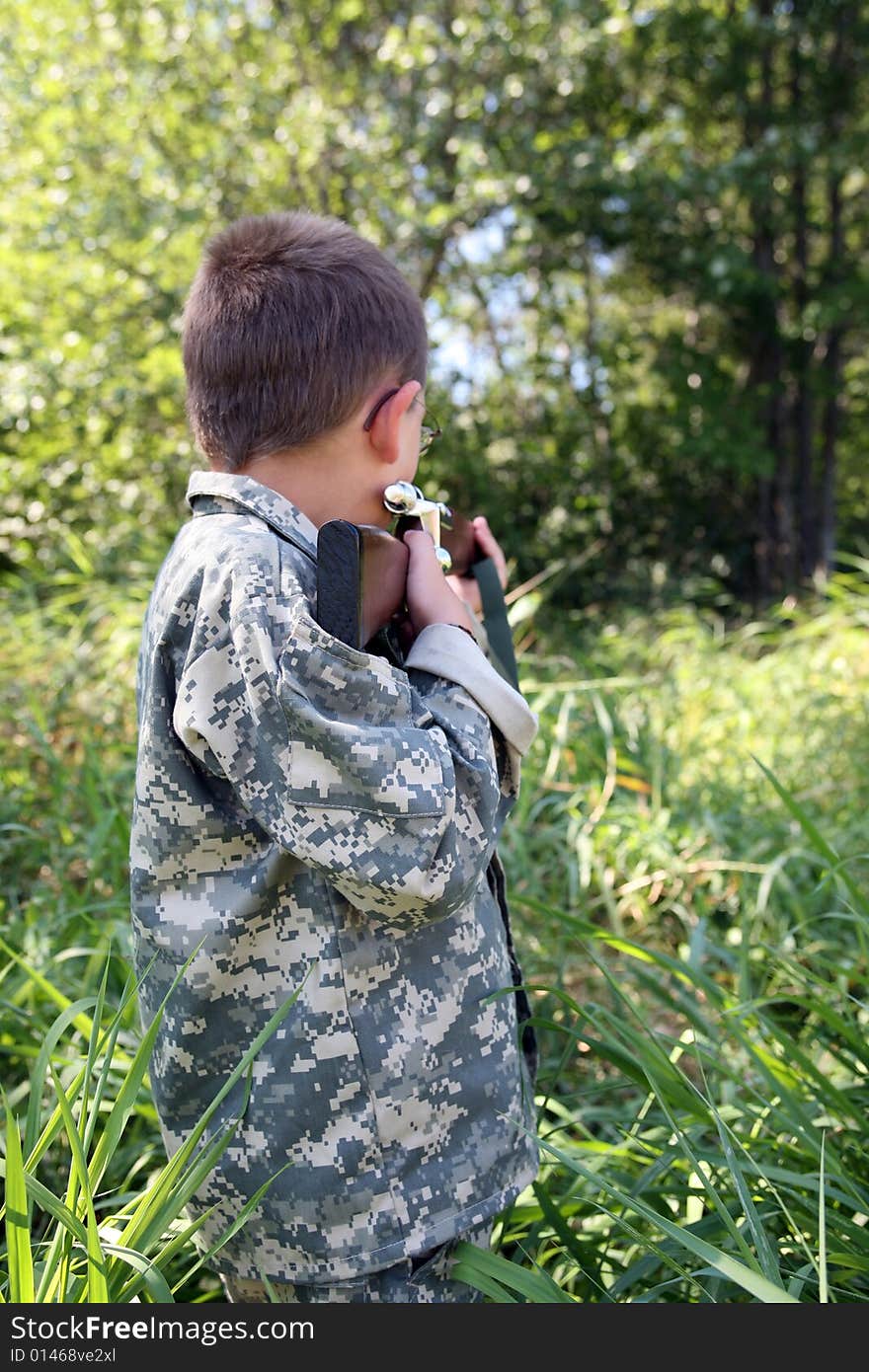 Young boy outside sighting in a rifle