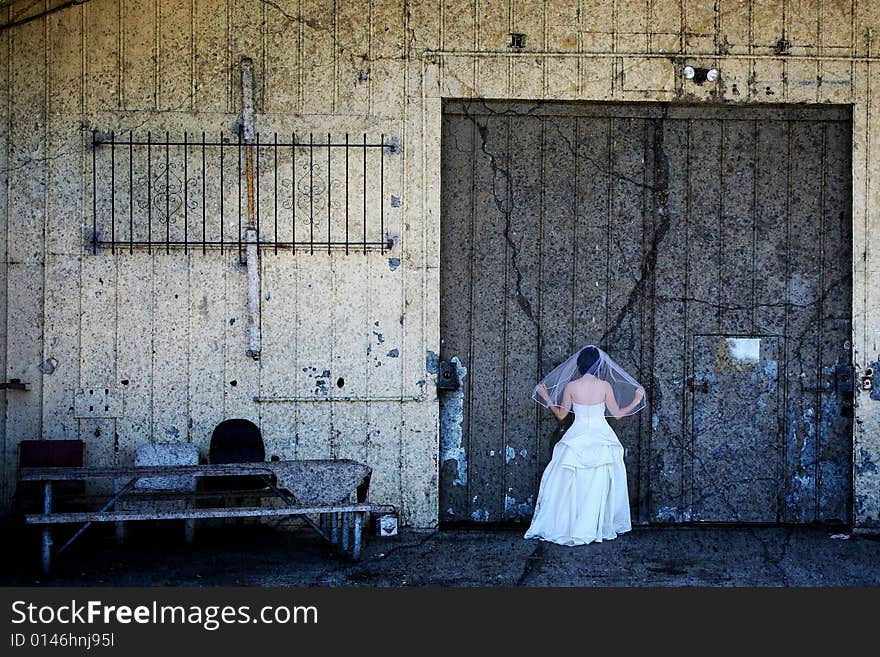 Bride in front of doors and abandoned building. Bride in front of doors and abandoned building