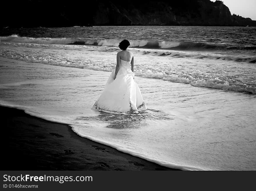 Bride wading in ocean water in San Francisco bay