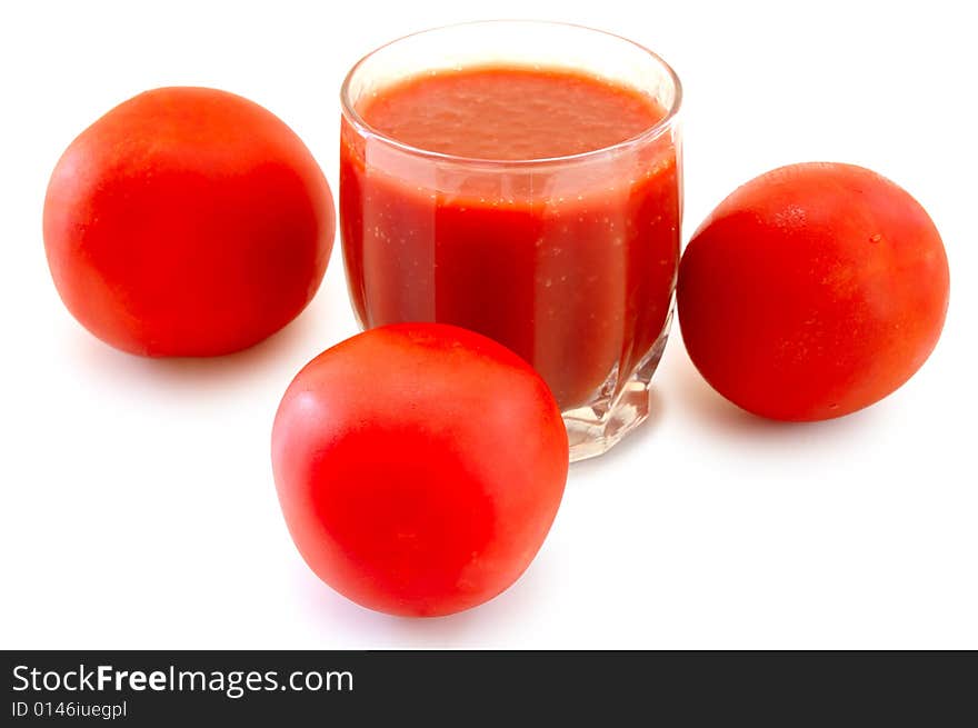 Fresh tomato juice in glass and tomatoes.