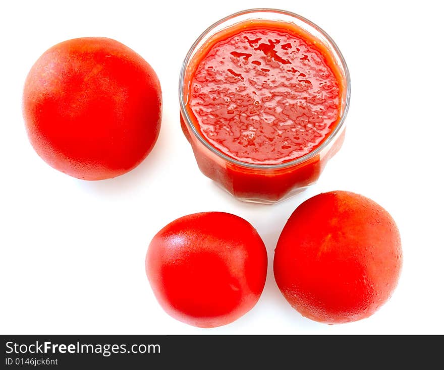 Fresh tomato juice in glass and tomatoes.