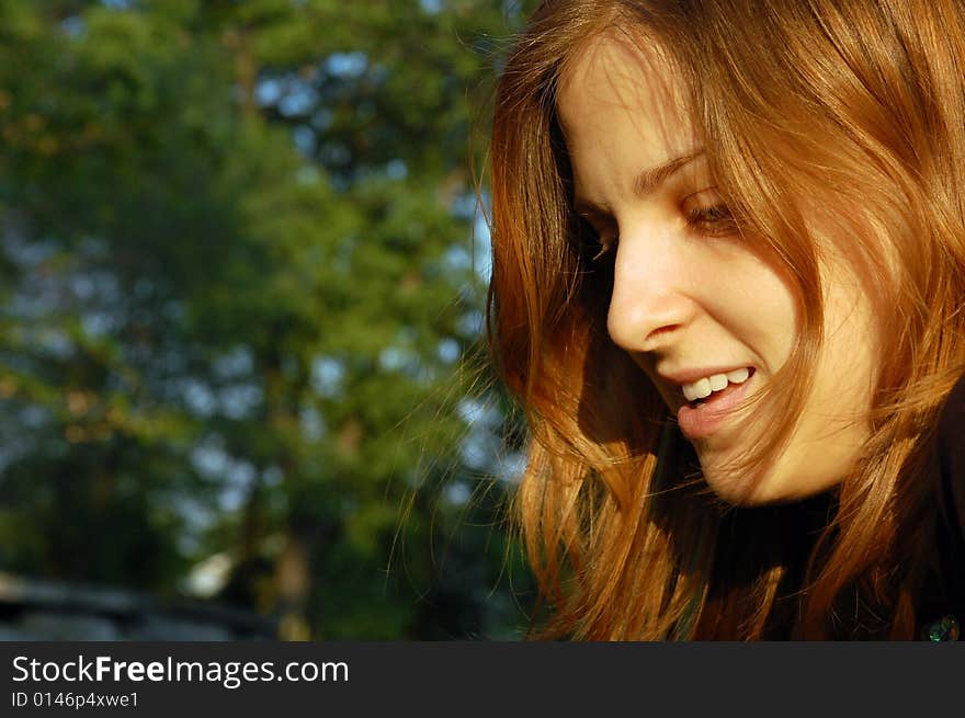 Portrait of a young woman looking down in the sunset light