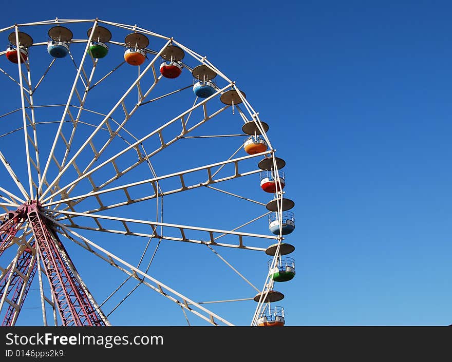 Ferris wheel on background blue sky