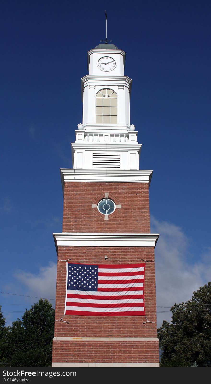 American flag on a brick and white clocktower