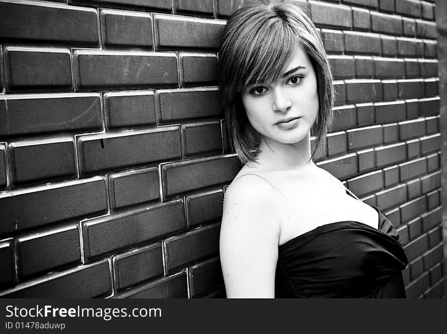 Beautiful blond woman on brick wall in black and white. Beautiful blond woman on brick wall in black and white.