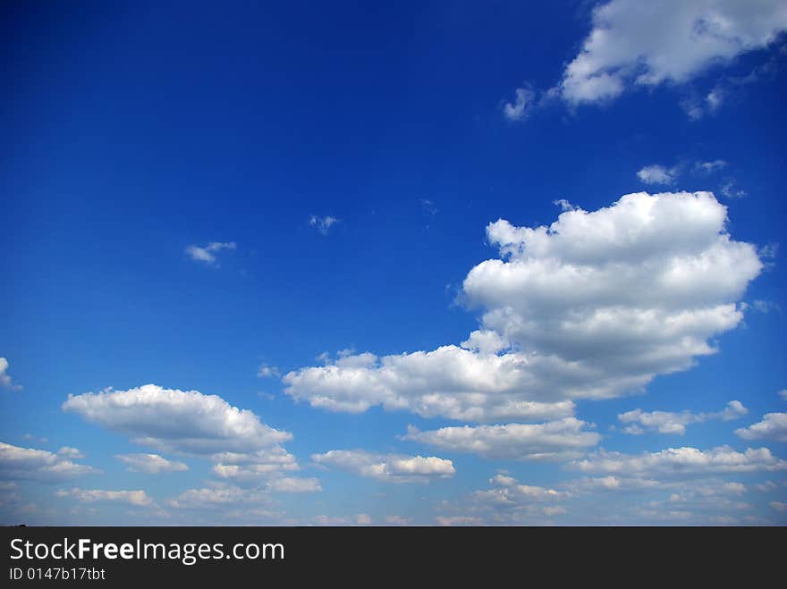 Blue sky background with tiny clouds