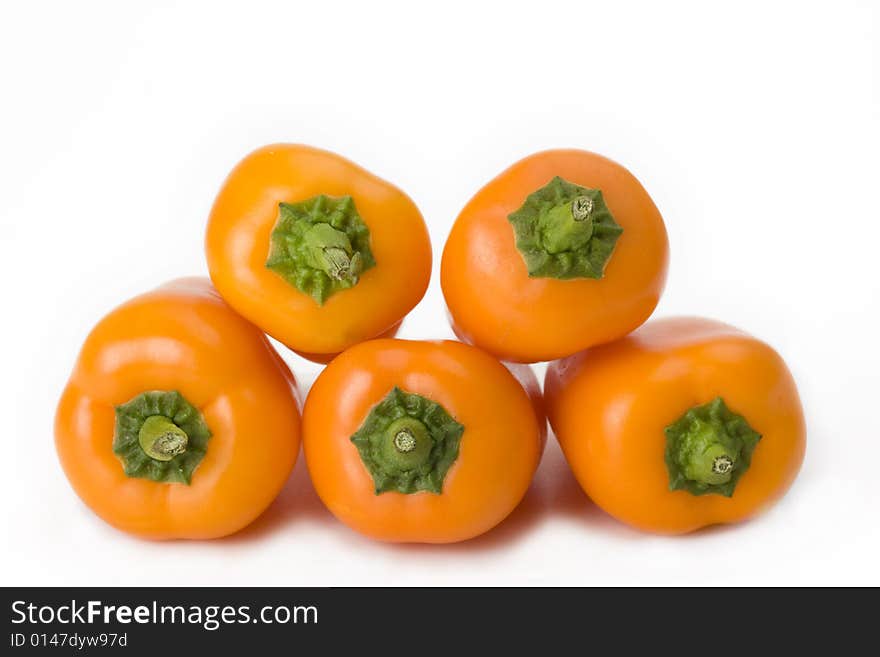 Five orange bell peppers on white background