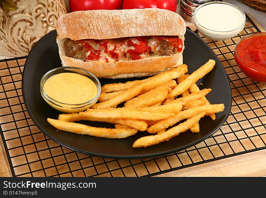 Italian meatball sandwich, spicy fries and honey mustard sauce. Italian meatball sandwich, spicy fries and honey mustard sauce.