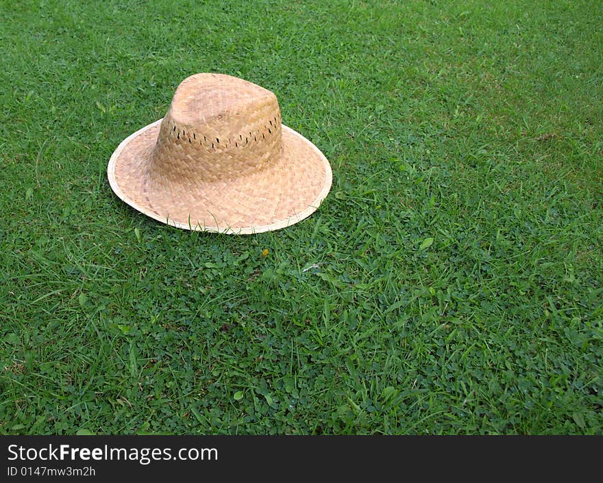 Straw Hat On Grass Lawn.