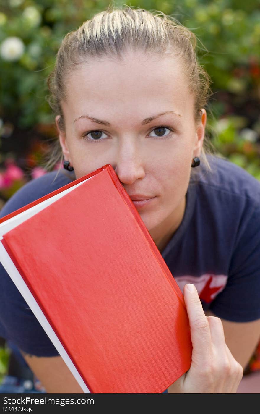 Outdoor portrait of woman with red book