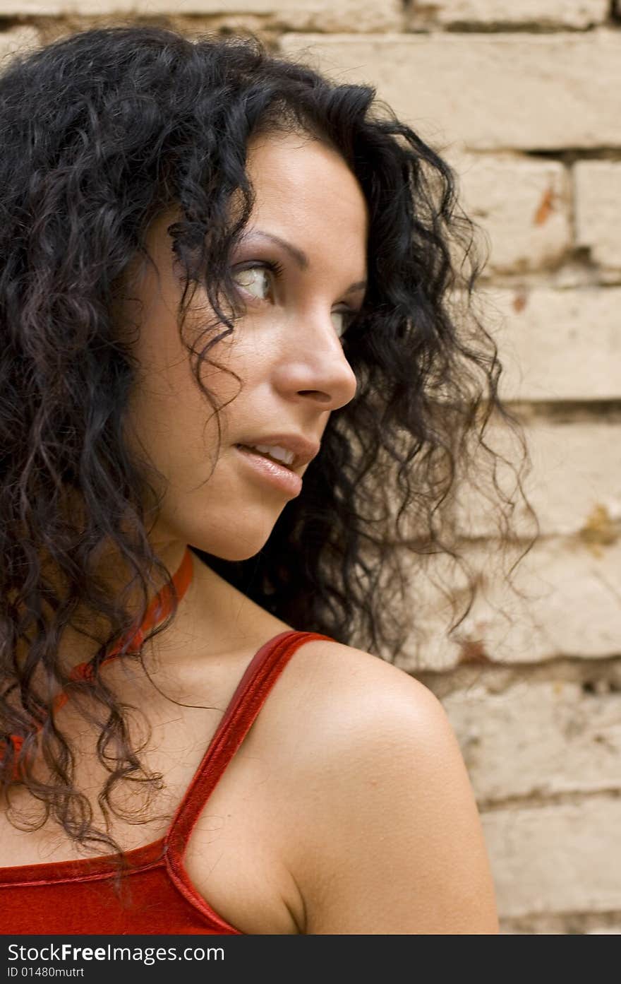 Closeup portrait of pretty brunette on brick wall background