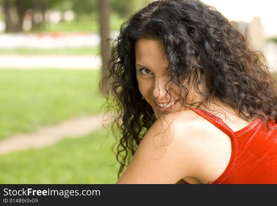 Outdoor portrait of beautiful brunet woman in red