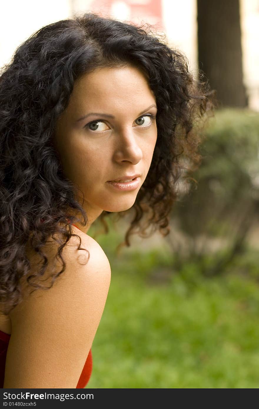 Outdoor portrait of beautiful brunet woman in red