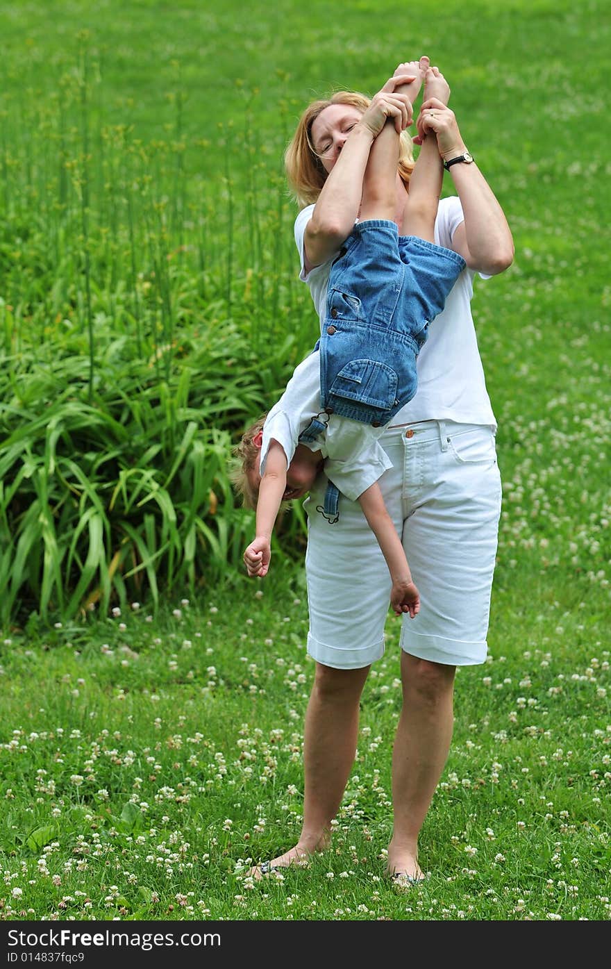 Mother playing with her son outdoors against a green background