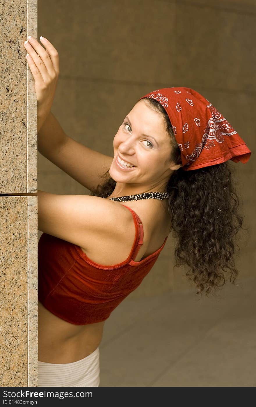 Outdoor portrait of pretty brunette near column