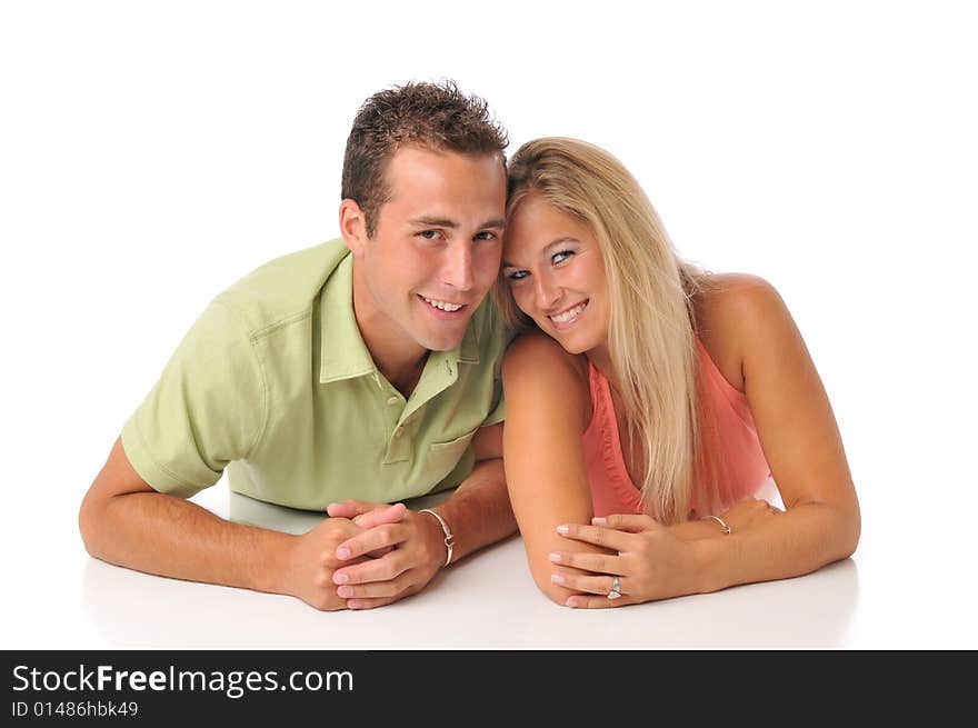 Young couple having fun lying down on the floor isolated on white