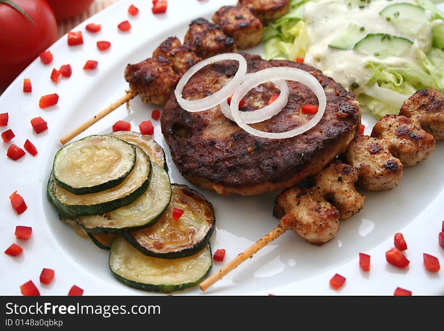 A plate with greg food, meat and tzaziki