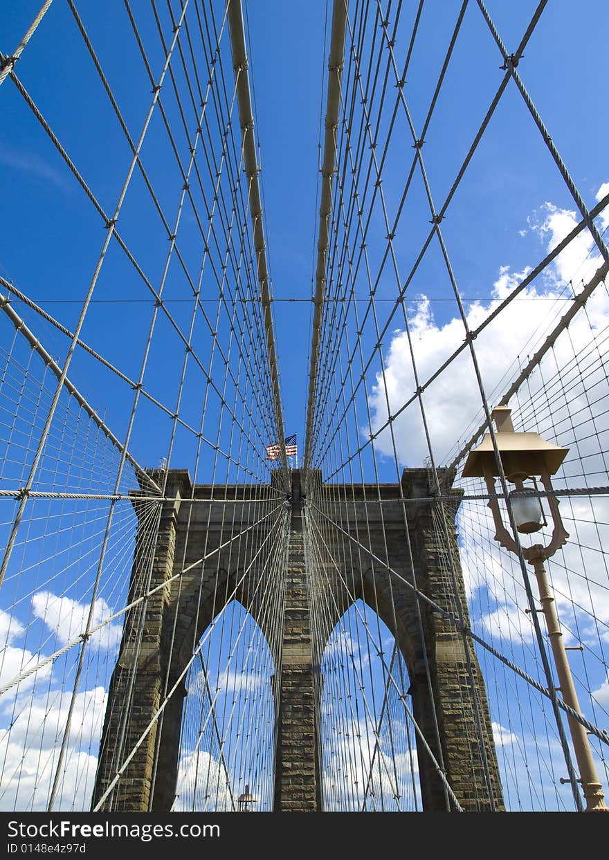 A view of the Brooklyn bridge with a blue sky on the background.