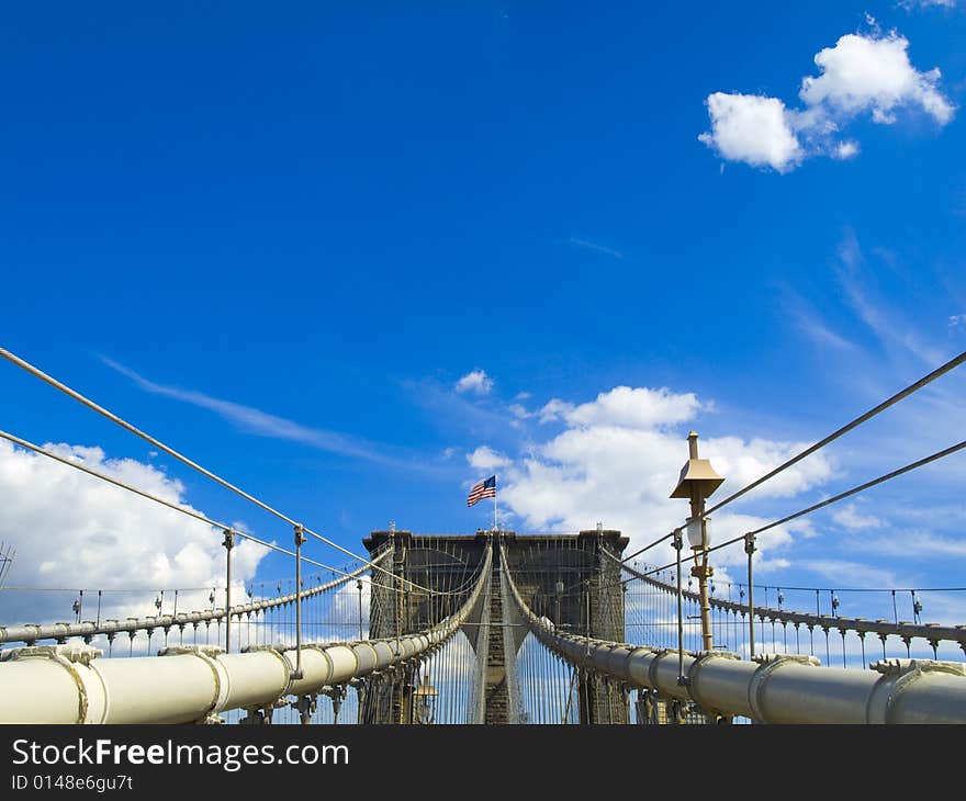 A view of the Brooklyn bridge with a blue sky on the background.