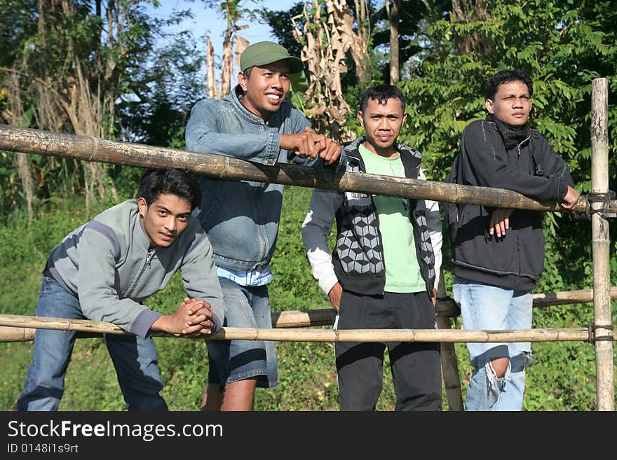 Four casual asian man stand at bamboo bridge