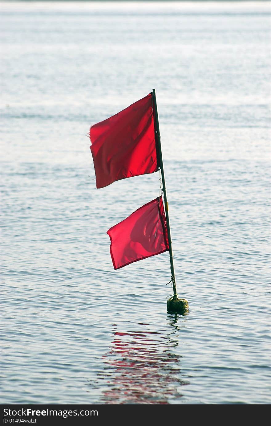 Fishing Net Flag. Red flag in the sea marking fishing net at the ocean floor.