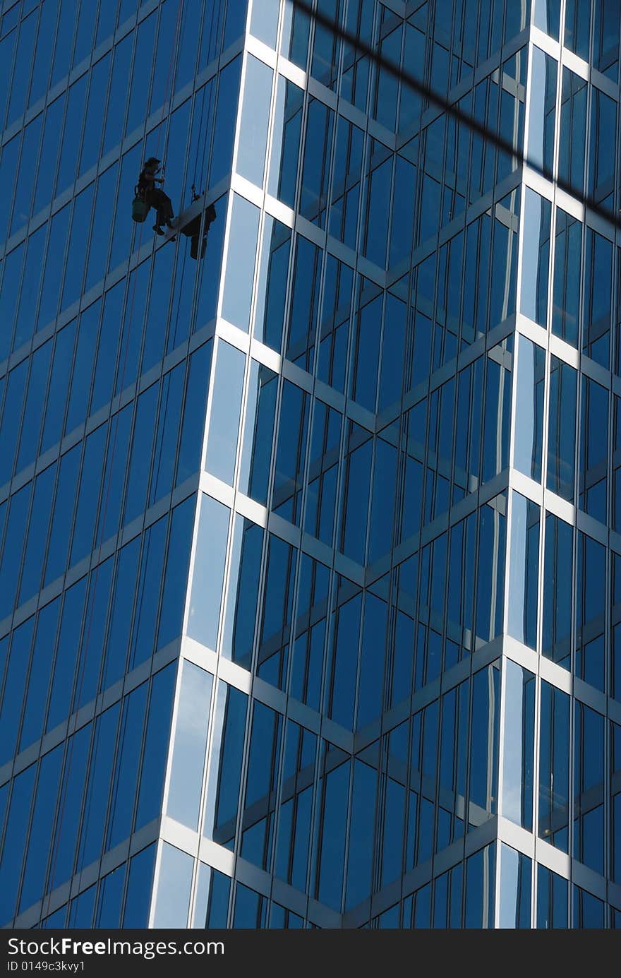 Window cleaner working on modern office building in Vancouver. Window cleaner working on modern office building in Vancouver