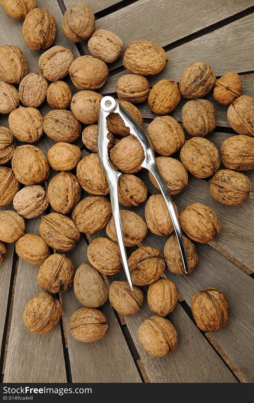 Nuts and nutcracker on garden table. Nuts and nutcracker on garden table