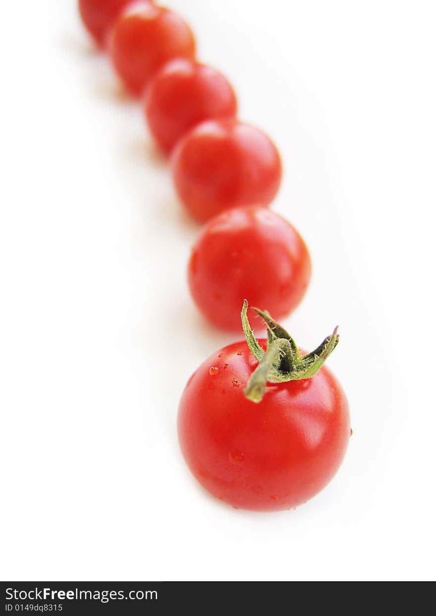 Red cherry tomatoes in line isolated on white