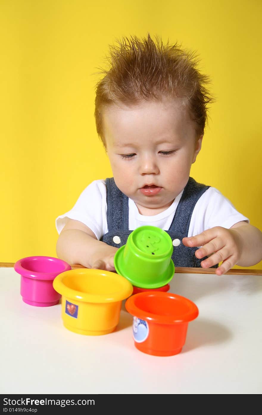 Baby plays with the collection of the small cups. Baby plays with the collection of the small cups