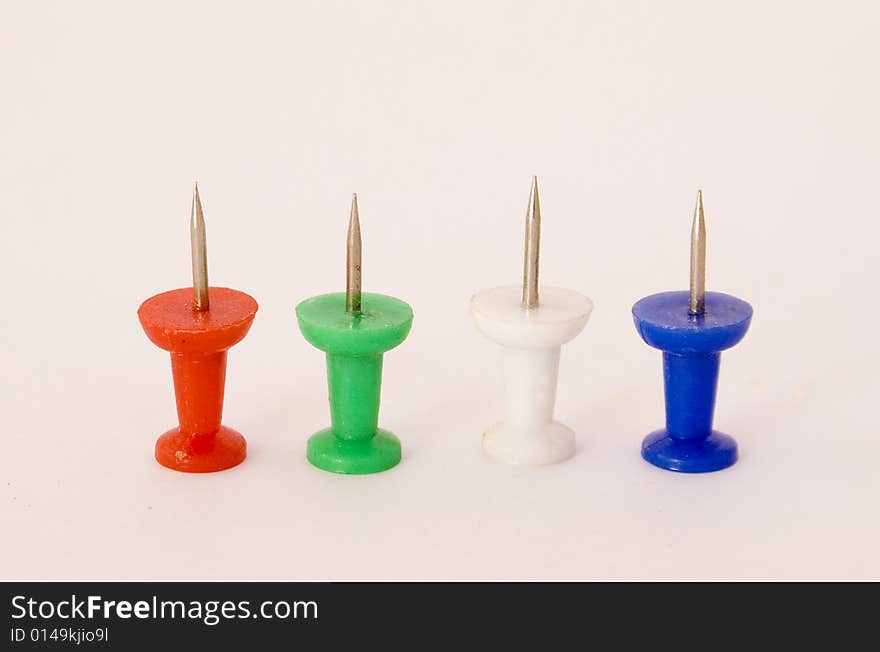 Four coloured push-pins standing on a white background. Four coloured push-pins standing on a white background