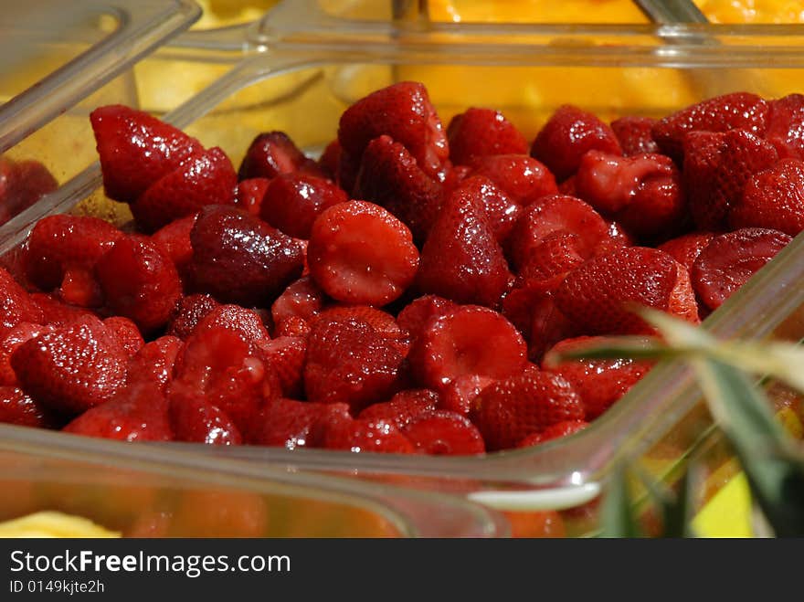 Strawberries and pineapples sit waiting for a tropical drink to be concocted. Strawberries and pineapples sit waiting for a tropical drink to be concocted.