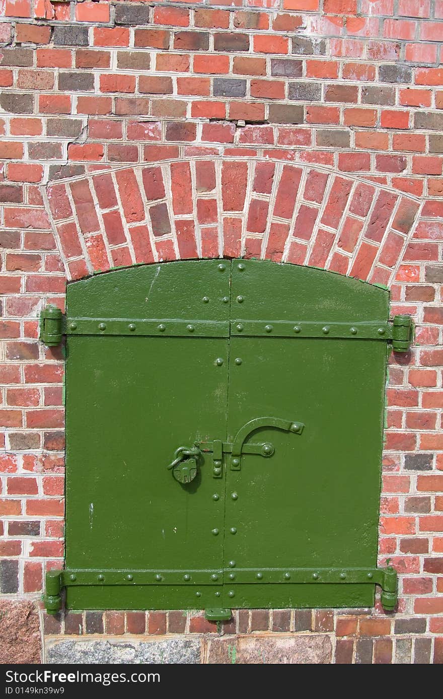 Old steel stronghold security door  in brick wall. Old steel stronghold security door  in brick wall