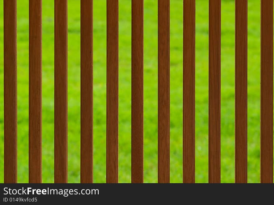 Brown wooden fence background over green lawn