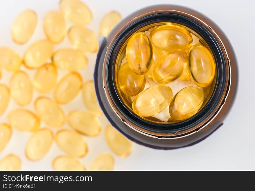 Closeup of yellow pills in a glass container