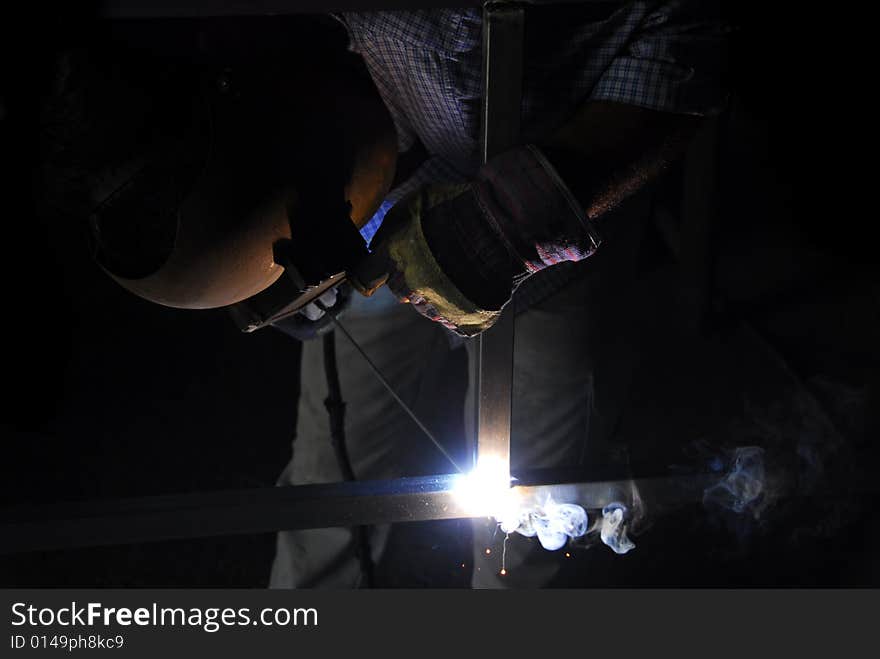 A welder makes a door by merging donate several pieces of metal. A welder makes a door by merging donate several pieces of metal.