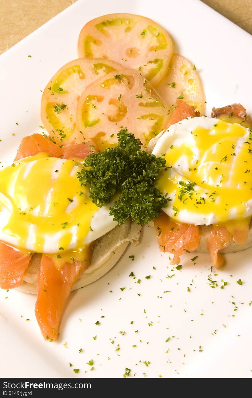 A plate of salmon and eggs with bread and tomatos