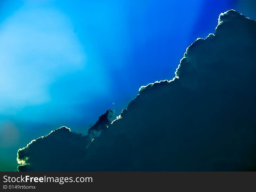 Sunlight rays coming from a dark cloud in the sky