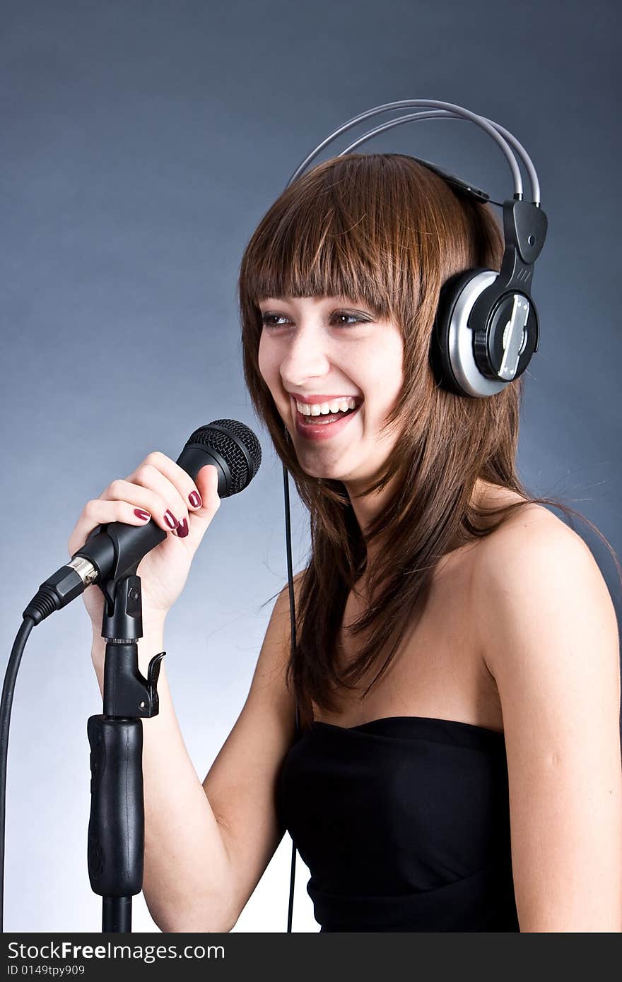 Woman in headphones Singing into Microphone