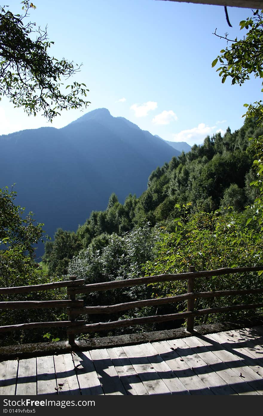 An alpine panorama during summer, a mountain is seen from a belvedere situated lower in the valley. An alpine panorama during summer, a mountain is seen from a belvedere situated lower in the valley