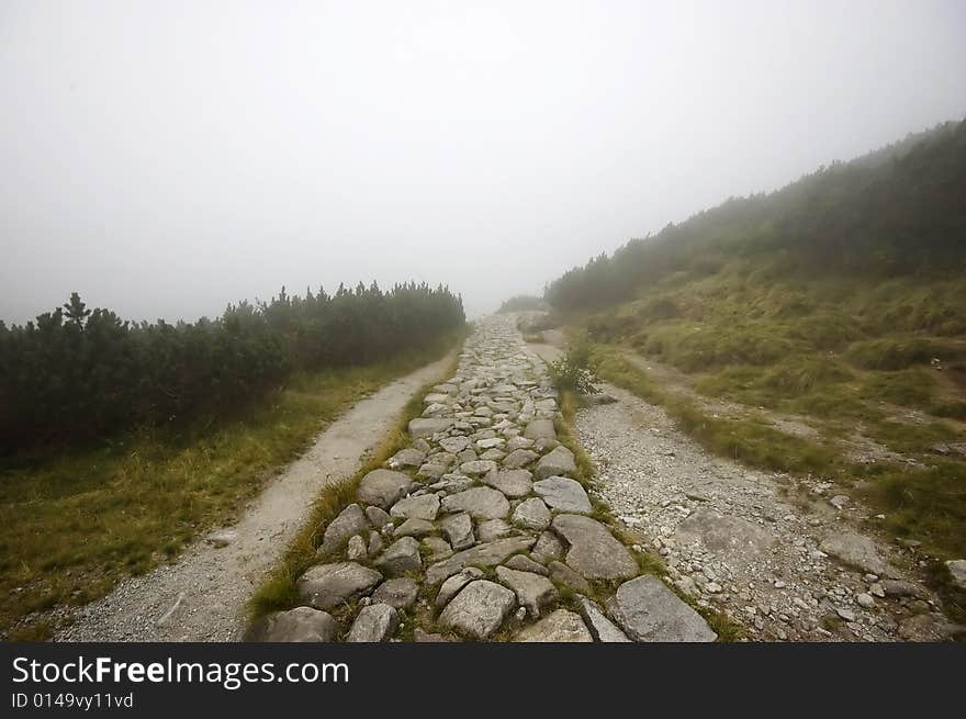 Misty pathway in Polish Tatras on an overcast day