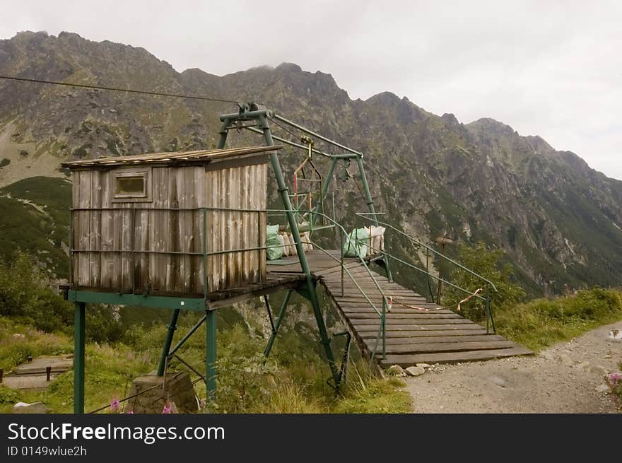 Mountain elevator construction for transporting goods via a metal wire