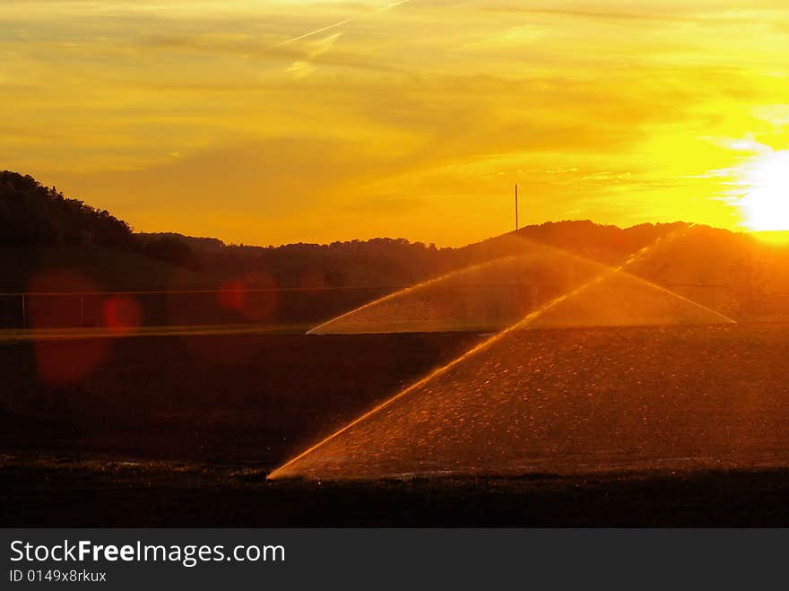 Time to water the field as the sun sets